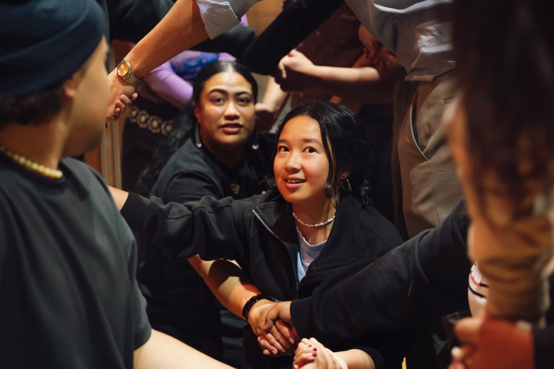 Young participants linking arms in a hands-on group exercise