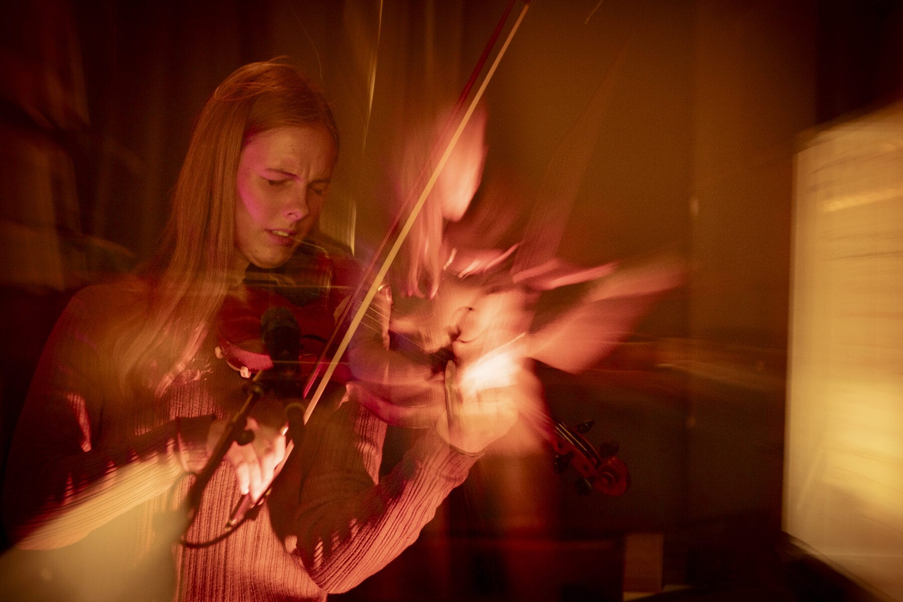 A young violinist playing in warm light
